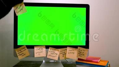 绿色电脑屏幕，有笔记。 概念。 带有绿色屏幕的计算机用纸贴在边缘周围。 妇女